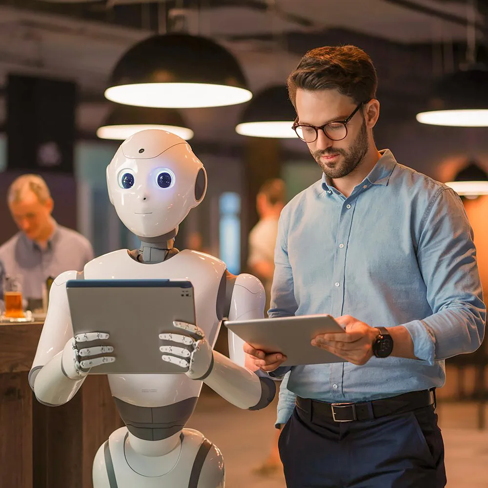 Humanoid robot and professional marketer side by side, each reviewing a tablet in a modern workspace.
