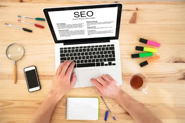 SEO copywriting workspace with a laptop showing search engine optimisation strategy, keywords and content planning.