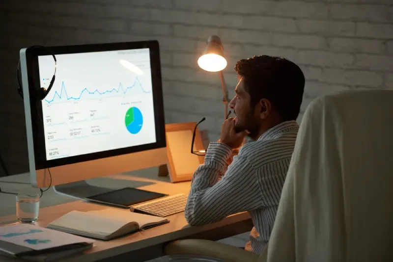 Strategist analysing funnel performance data and conversion metrics on a large monitor.