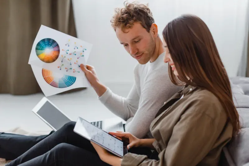 Two specialists reviewing analytics dashboards and user behaviour data on a laptop.
