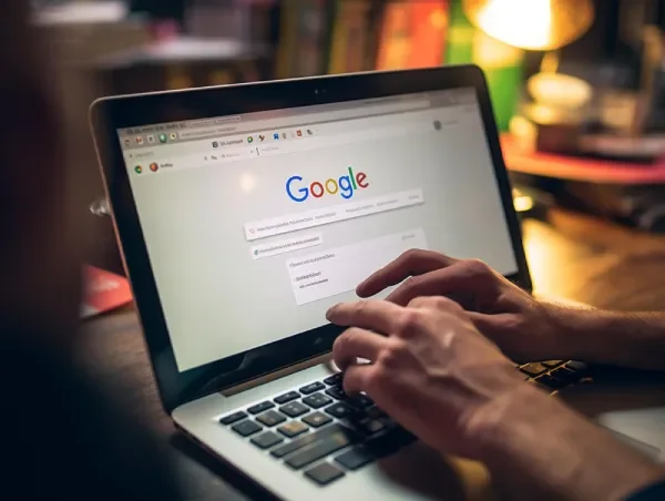Hands typing on laptop showing Google search, representing transparent Google Ads pricing without spend markups.