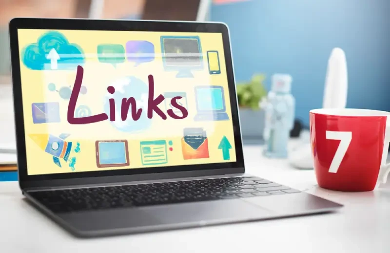Laptop on a desk displaying a Links graphic with cloud, email and web icons for link building and off-page SEO.