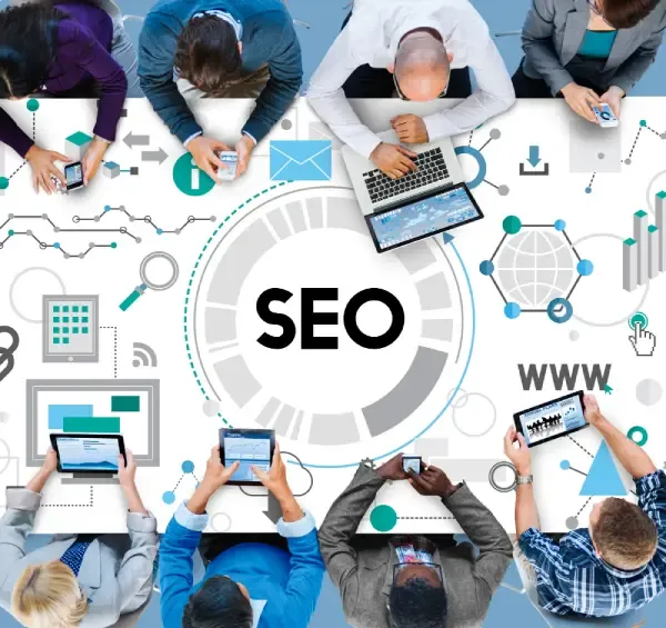 Team around a table with devices collaborating over a central SEO graphic and analytics icons.