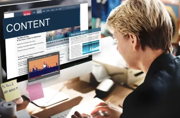 Professional reviewing a large monitor displaying articles, video, charts, and a prominent Content banner.